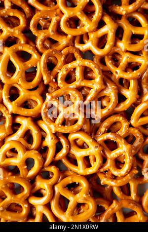 Mini Pretzel con sale su una superficie grigia, vista dall'alto. Giacitura piana, sovratesta, dall'alto. Foto Stock