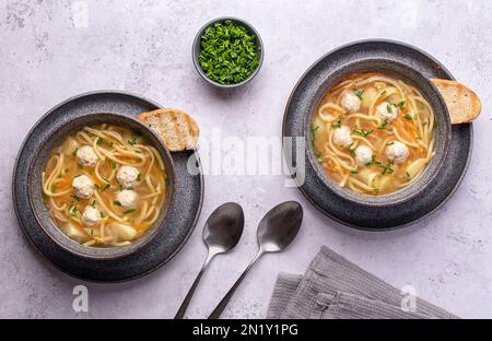Fotografia alimentare di zuppa con polpette e tagliatelle, verdure, carote, erba cipollina, patate Foto Stock