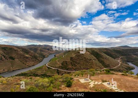 La valle del Douro con il suo fiume e i suoi vigneti coltivati a terrazze sulle montagne. Superbo cielo nuvoloso riflesso nelle acque del fiume. Foto Stock