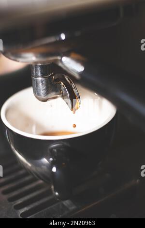 Primo piano di erogazione dell'espresso dalla macchina da caffè. Caffè professionale. Barista Foto Stock
