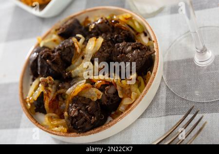 Salsiccia tradizionale spagnola di sangue di morcilla servita con cipolle Foto Stock