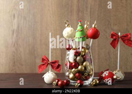 Deliziosi dolci natalizi a tema pops su tavolo di legno Foto Stock