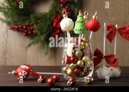 Deliziosi dolci natalizi a tema pops su tavolo di legno Foto Stock