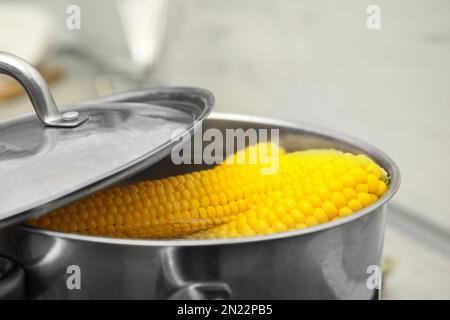 Pentola con pannocchie di mais bollenti in cucina, primo piano Foto Stock