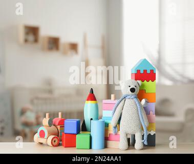 Set di diversi giocattoli carini su un tavolo di legno nella stanza dei bambini Foto Stock