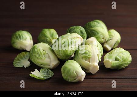 Germogli freschi di Bruxelles su tavola di legno marrone, primo piano Foto Stock