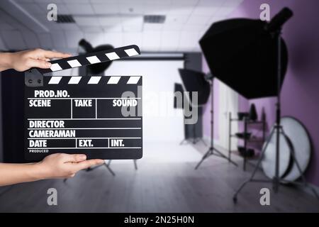 Assistente che tiene il clapperboard sulla posizione della ripresa, primo piano. Produzione cinematografica Foto Stock