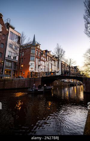 Vista sul canale di Amsterdam. Edifici storici e colorati ad Amsterdam, nei Paesi Bassi. Amsterdam al tramonto a febbraio. Foto Stock