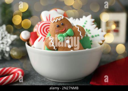 Gustosi biscotti di Natale decorati in ciotola sul tavolo. Effetto bokeh Foto Stock