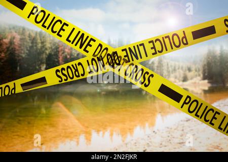 Nastro giallo della polizia che isola la scena del crimine. Vista sfocata del lago di montagna Foto Stock