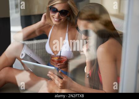 Cocktail a bordo piscina. Due amici che abbronzano con cocktail nelle loro mani. Foto Stock