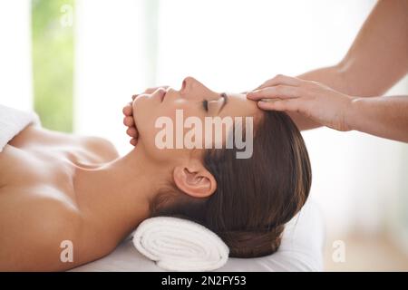 Puro relax. Una giovane donna che riceve un massaggio alla testa in una spa. Foto Stock