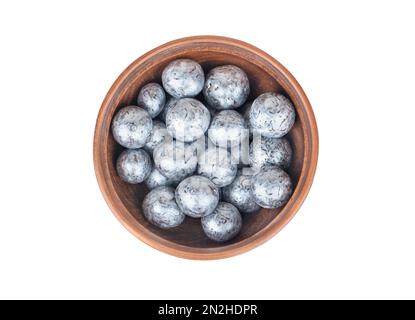 Nocciole al cioccolato in una ciotola di ceramica isolata su sfondo bianco, vista dall'alto Foto Stock