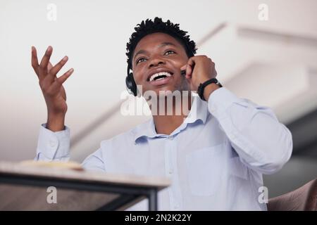 Call center, black man e comunicazione in basso angolo per assistenza clienti, telemarketing e consulente in ufficio. Agente di vendita che parla con l'auricolare per Foto Stock