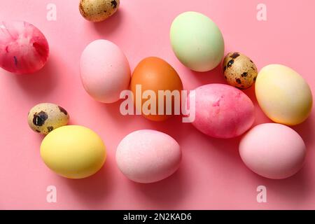 Uova di Pasqua naturali e dipinte su sfondo rosa Foto Stock