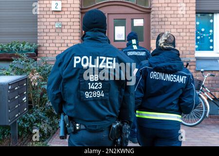 07 febbraio 2023, Brandeburgo, Cottbus: Le forze di emergenza dell'Ufficio dell'ordine pubblico della città di Cottbus e la polizia stanno suonando campane a casa. A partire da mezzogiorno di oggi, cercheranno di disinnescare una bomba aerea che è stata trovata durante i lavori di costruzione di giovedì. A tal fine è stata istituita una zona di esclusione di 1000 metri, in cui sono situate le case di circa 3800 persone, una scuola e un centro di cura, la stazione centrale di Cottbus e altre imprese commerciali. E 'dalle ore 8, evacuato. Il dispositivo esplosivo, che pesa circa 100 kg e comprende un fusibile di tipo russo Foto Stock