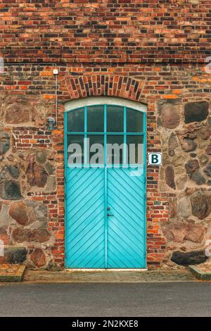 Rustico porta di legno di un vecchio edificio con lettera B segno a Halmstad, Svezia. Esempio di stile architettonico scandinavo. Foto Stock