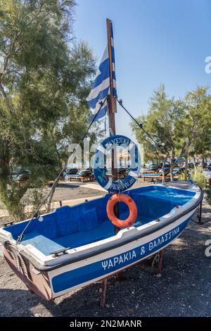 Perivolos Beach, Santorini, Grecia - Agosto 2022 : nave da pesca in legno blu usata per pubblicizzare la taverna locale su una popolare spiaggia di Santorini Foto Stock