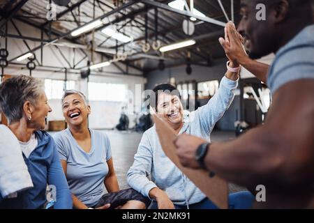 High Five, gruppo o squadra di fitness senior donne in palestra dopo l'esercizio fisico, allenamento o l'allenamento con personal trainer. Anziani, anziani e persone felici Foto Stock