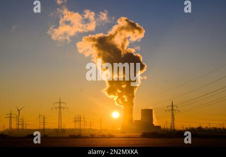 Hohenhameln, Germania. 07th Feb, 2023. Il sole sorge dietro la centrale di Mehrum nel distretto di Peine. La centrale a carbone è tornata in rete come "rimessa di mercato” dall'agosto 2022. Un’ordinanza aveva permesso alle centrali elettriche alimentate a carbone duro della cosiddetta riserva di rete di tornare in funzione per risparmiare gas naturale. Credit: Julian Stratenschulte/dpa/Alamy Live News Foto Stock