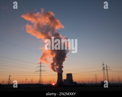 Hohenhameln, Germania. 07th Feb, 2023. Il sole sorge dietro la centrale di Mehrum nel distretto di Peine. La centrale a carbone è tornata in rete dall'agosto 2022 come rimessa al mercato. Un’ordinanza aveva permesso alle centrali elettriche alimentate a carbone duro della cosiddetta riserva di rete di tornare in funzione per risparmiare gas naturale. Credit: Marco Rauch/dpa/Alamy Live News Foto Stock