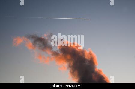 Hohenhameln, Germania. 07th Feb, 2023. All'alba, due aeroplani disegnano contraddii nel cielo sopra la centrale Mehrum nel distretto di Peine. La centrale a carbone è tornata in rete come "rimessa di mercato” dall'agosto 2022. Un decreto aveva consentito alle centrali elettriche alimentate a carbone duro della cosiddetta riserva di rete di tornare in funzione per risparmiare gas naturale. Credit: Julian Stratenschulte/dpa/Alamy Live News Foto Stock