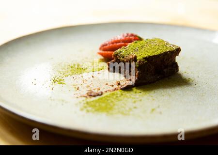 Metà di una porzione di soffice torta al cioccolato Matcha Foto Stock