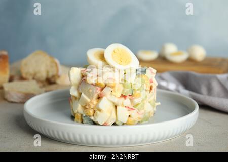 Insalata deliziosa con bastoncini di granchio e uova sul tavolo, primo piano Foto Stock