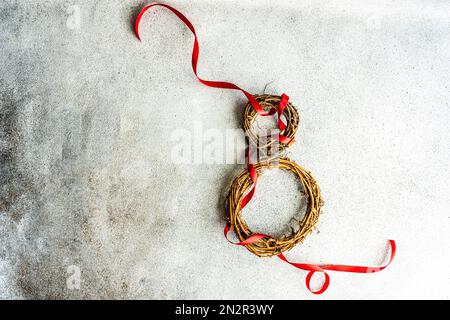 Vista dall'alto di due corone di vite con nastri rossi a forma di numero 8 Foto Stock