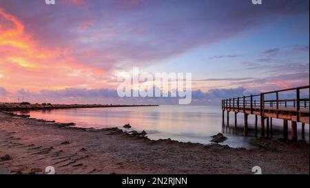 Spiaggia di Santa Pola con un molo e bella alba. Paesaggio della costa mediterranea nella città di Santa pola. Città costiera situata nel com di Valencia Foto Stock