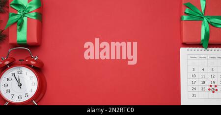 Calendario cartaceo con data di Santo Stefano, sveglia e regali su sfondo rosso, piatto. Spazio per il testo Foto Stock