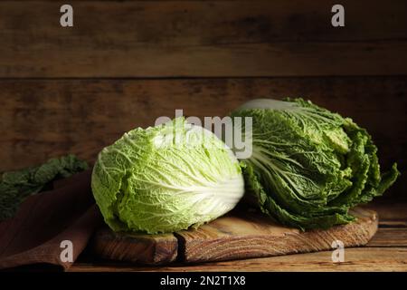 Cavoli cinesi maturi freschi su tavolo di legno Foto Stock