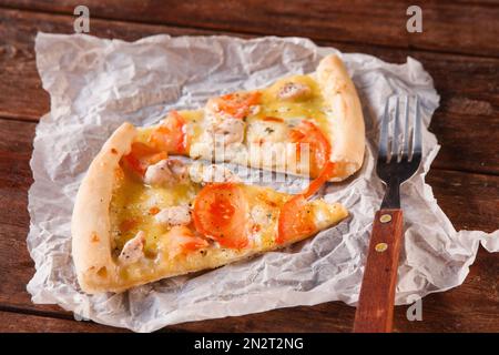 Fette di pizza fresca su tovagliolo bianco con forchetta Foto Stock