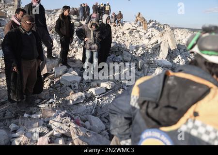 Harem, Siria. 07th Feb, 2023. Civili e membri dei caschi bianchi ispezionano un edificio che è crollato nella città di Harem a seguito del devastante terremoto che ha colpito il confine turco-siriano e ha lasciato più di 5000 persone morte. Credit: ANAS Alkharboutli/dpa/Alamy Live News Foto Stock