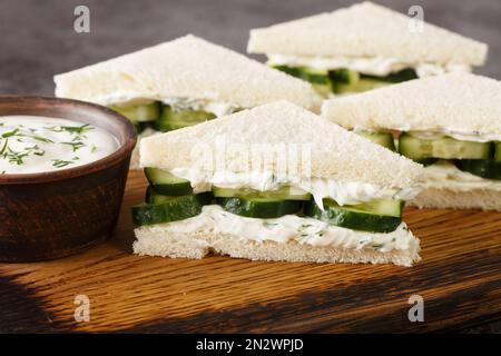 Sandwich al formaggio cremoso al cetriolo, primo piano sul pannello di legno sul tavolo. Orizzontale Foto Stock