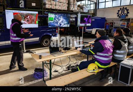 Wesel, Germania. 07th Feb, 2023. I dipendenti di varie organizzazioni di soccorso seguono l'uso di droni e robot su monitor. Esperti della protezione civile provenienti da tutta Europa hanno testato la localizzazione e il salvataggio delle vittime sepolte con aiuti moderni come droni e robot in un'operazione di terremoto simulata a Wesel. (A dpa/lnw: 'Gli esperti praticano la missione di salvataggio del terremoto con l'alta tecnologia sul basso Reno') Credit: Oliver Berg/dpa/Alamy Live News Foto Stock