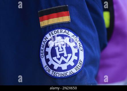 Wesel, Germania. 07th Feb, 2023. La bandiera e il logo dell'Agenzia federale tedesca per il soccorso tecnico (THW) sono appesi alla giacca di un dipendente. Esperti di gestione delle catastrofi provenienti da tutta Europa hanno testato la localizzazione e il salvataggio delle vittime sepolte con aiuti moderni come droni e robot durante un'operazione di terremoto simulata a Wesel. (A dpa/lnw: 'Gli esperti praticano la missione di salvataggio del terremoto con l'alta tecnologia sul basso Reno') Credit: Oliver Berg/dpa/Alamy Live News Foto Stock