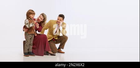 Ritratto di famiglia giovane, madre, padre e figlio piccolo in abiti retrò isolato su sfondo bianco. Concetto di stile retrò, 60s, 70s Foto Stock