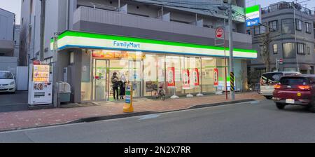 La foto di un affollato FamilyMart, un famoso minimarket giapponese al crepuscolo dopo aver illuminato le luci del negozio. Foto Stock