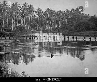 GUADALCANAL, Isole SALOMONE - circa 1942-1943 - i Marines statunitensi attraversano un corpo d'acqua in una pattuglia serale durante la battaglia di Guadalcanal nel Salomone Foto Stock
