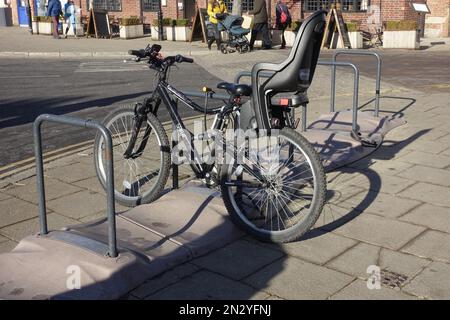 Bicicletta moderna con seggiolino per bambini parcheggiato nel portabiciclette Stratford su Avon UK Foto Stock