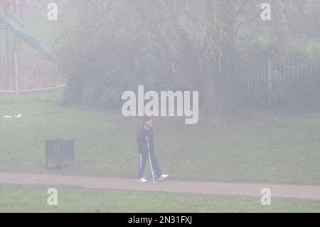 Windsor, Berkshire, Regno Unito. 7th febbraio, 2023. Un uomo cammina lungo la nebbia sul Tamigi Path vicino al Tamigi a Windsor. Dopo un inizio chiaro alla mattina, la nebbia fitta più tardi si è rivestita di Windsor nel Berkshire questa mattina. Credit: Maureen McLean/Alamy Live News Foto Stock