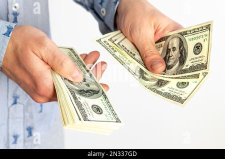 Il businessman conta le fatture per 100 dollari. Dollari nelle mani di un uomo Foto Stock