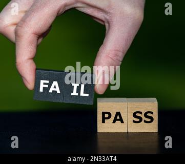 La mano seleziona i cubi con la parola 'fail' invece dei cubi con la parola 'pass'. Simbolo per la mancata esecuzione di un test. Foto Stock