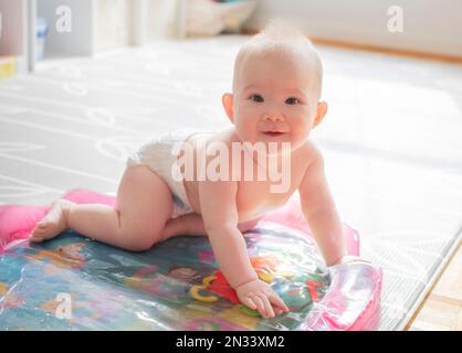 Cute piccola ragazza caucasica bambino imparando come strisciare Foto Stock