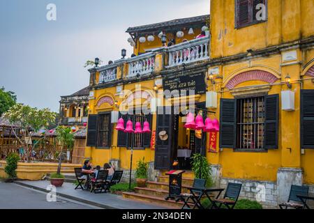 Lanterne viola appese all'ingresso di un ristorante giallo a Hoi An, Vietnam. Foto Stock
