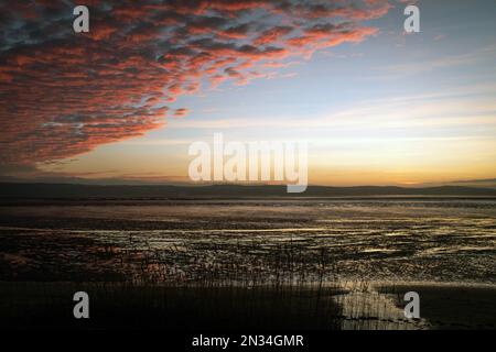 Tramonto sull'estuario del Dee, raffigurato da Cubbins Green, West Kirby, Wirral, che si affaccia sulla costa del Galles del Nord in una serata di febbraio. Foto Stock