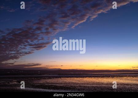 Tramonto sull'estuario del Dee, raffigurato da Cubbins Green, West Kirby, Wirral, che si affaccia sulla costa del Galles del Nord in una serata di febbraio. Foto Stock