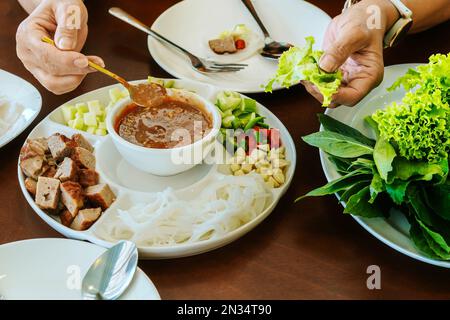 Primo piano con salsa per involtini di polpette vietnamite (Nam-Neung), involtini di salsiccia di maiale con verdure fresche in carta di riso, generoso piatto con cui mangiare Foto Stock