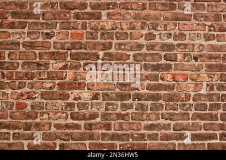 Un vecchio muro di mattoni stagionato da utilizzare come sfondo o struttura. Foto Stock
